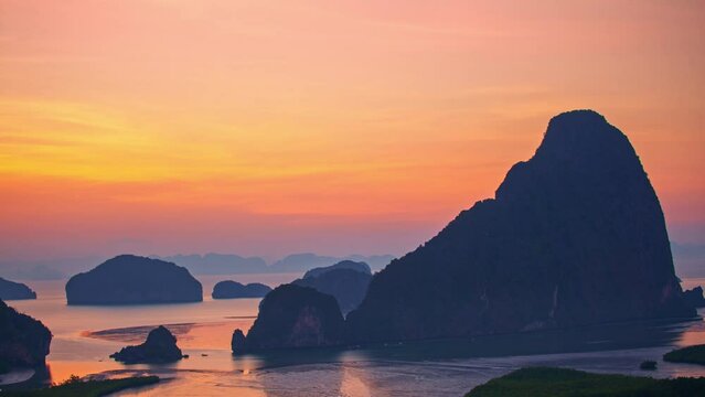 .Time lapse Amazing red sky above the island in Samed Nang Chee Phang Nga. .the flare light from the sun shines above the islands. .early sunrise at Samed Nang Chee archipelago. archipelago background