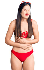Fototapeta premium Young beautiful caucasian woman wearing bikini with hand on stomach because nausea, painful disease feeling unwell. ache concept.