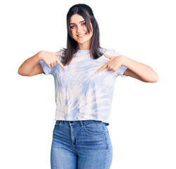 Young beautiful girl wearing casual t shirt looking confident with smile on face, pointing oneself with fingers proud and happy.