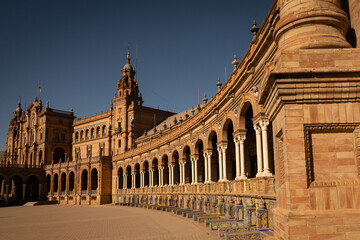 Fototapeta na wymiar The National Geographic Institute in Plaza de España Seville city Spain. Central government offices in stunning rich wealthy architecture design on sunny day. Impressive symmetrical masonry 