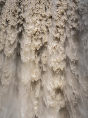 Detail of a powerful waterfall in Iceland. Muddy coloured water.