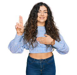 Young hispanic girl wearing casual clothes smiling swearing with hand on chest and fingers up,...