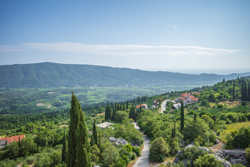 View from Sokol fortress, Croatia, to cliffs grown with green cypresses and road through the valley