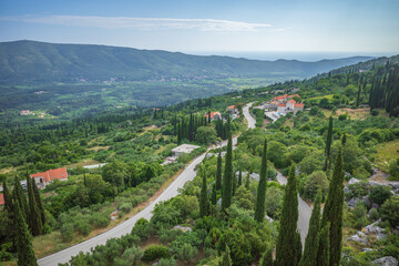 View from Sokol fortress, Croatia, to cliffs grown with green cypresses and road through the valley