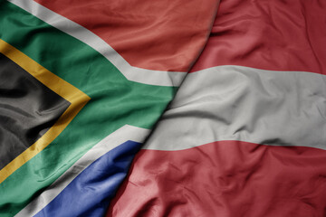 big waving national colorful flag of austria and national flag of south africa .