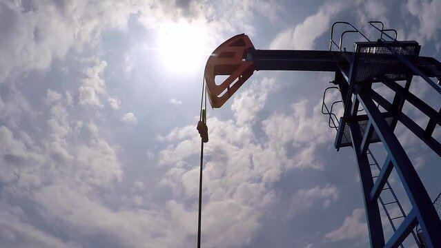 Oil Well Pump Jack Against The Sky. Oil Industry Equipment. Pump Jack Pumping Crude Oil from Underground Reservoirs. CO2 Emission Intensity of Crude Oil Production.