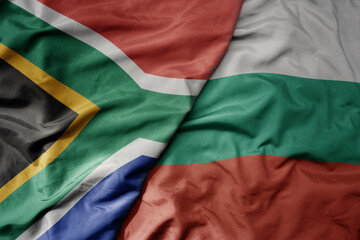 big waving national colorful flag of bulgaria and national flag of south africa .