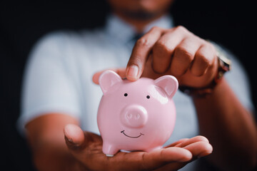 Financial concept, man holding piggy bank on wooden table Financial concepts, business, finance,...