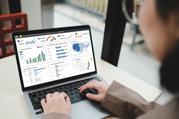 Businesswoman working on laptop with business dash board analytics chart metrics KPI to analyze the...
