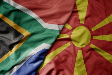 big waving national colorful flag of macedonia and national flag of south africa .
