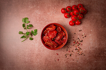 dried tomatoes, in a bowl, top view, on a brown background,