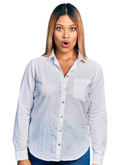 Young hispanic woman wearing casual white shirt afraid and shocked with surprise expression, fear and excited face.