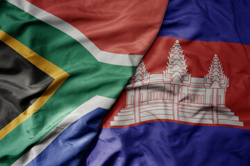 big waving national colorful flag of cambodia and national flag of south africa .