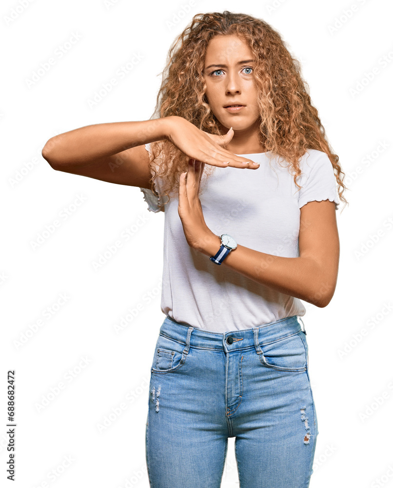 Wall mural Beautiful caucasian teenager girl wearing casual white tshirt doing time out gesture with hands, frustrated and serious face