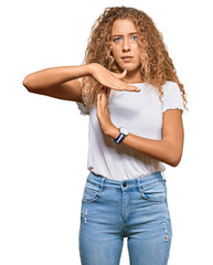 Beautiful caucasian teenager girl wearing casual white tshirt doing time out gesture with hands,...