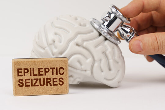 Using a stethoscope, the brain is diagnosed, next to it is a sign with the inscription - epileptic seizures