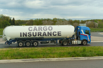 On a tank truck driving along the road there is an inscription - Cargo insurance