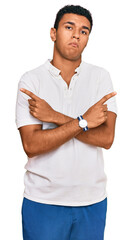 Young arab man wearing casual clothes pointing to both sides with fingers, different direction disagree