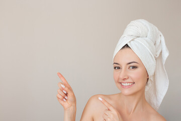 close-up photo of a young nude woman with a white towel wrapped around her head, she smiling and...