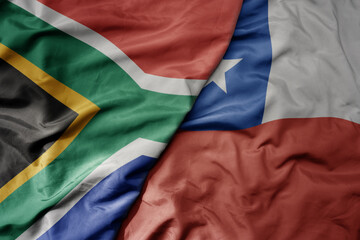 big waving national colorful flag of chile and national flag of south africa .