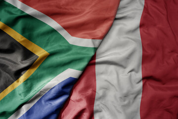 big waving national colorful flag of peru and national flag of south africa .