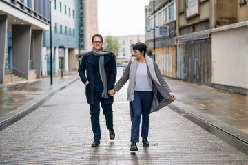 Handsome man and beautiful woman hugging each other as they walk around the city, dancing on the street, having a fun time, lifestyle photo