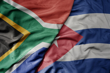 big waving national colorful flag of cuba and national flag of south africa .