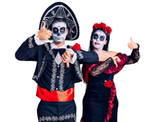 Young couple wearing mexican day of the dead costume over background doing thumbs up and down, disagreement and agreement expression. crazy conflict