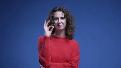 Woman giving OK signal with Hands. Female person in 20s showing approval