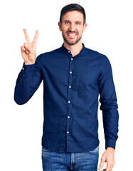 Young handsome man wearing casual shirt smiling looking to the camera showing fingers doing victory sign. number two.