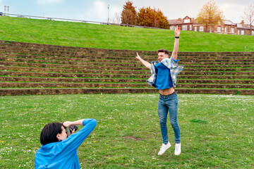 Obraz premium Smiling young couple taking photos each other and having a fun