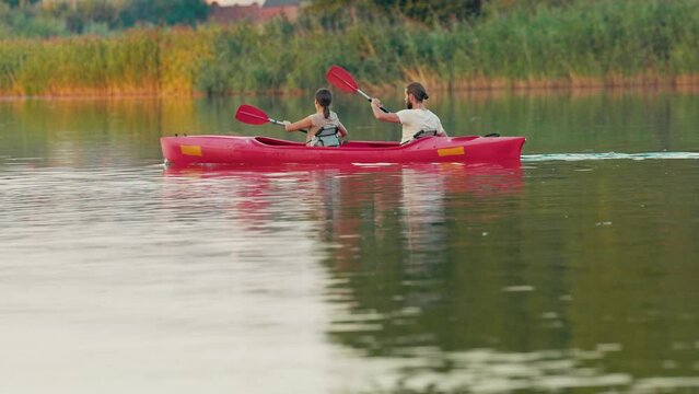 Back view of Caucasian couple spending time together romantically. In free time learning new type of sport. Boosting their learning curve. Trying to hold balance and paddle correctly.