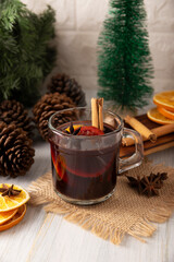Obraz na płótnie Canvas Spiced wine or Christmas mulled wine with orange, cinnamon, star anise, clove, nutmeg and other ingredients on a wooden rustic table. Traditional hot drink at winter time and Christmas holidays.