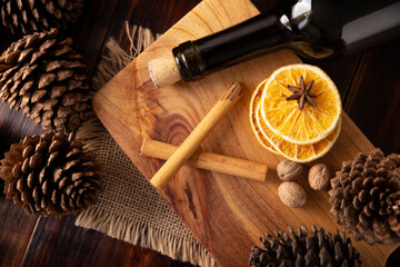 ingredients to prepare mulled wine recipe with orange, cinnamon, star anise, clove, nutmeg and other ingredients on a wooden table. Traditional hot drink at winter time and Christmas holidays.