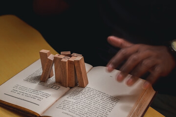Wooden domino concept, businessmen invest, analyze, plan operations to achieve goals with minimal...
