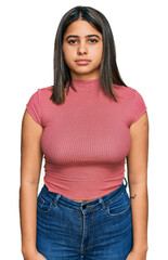 Young hispanic girl wearing casual t shirt relaxed with serious expression on face. simple and...