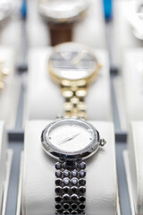 A collection of expensive watches on the window of a luxury goods and jewelry store.