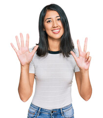 Beautiful asian young woman wearing casual white t shirt showing and pointing up with fingers number eight while smiling confident and happy.