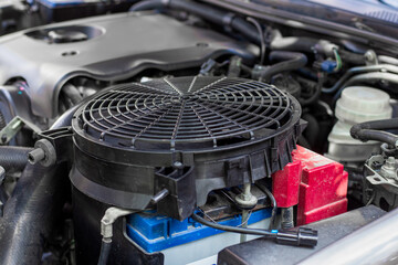 The engine cooling fan is prepared for installation under the hood of a car. Machine maintenance and repair
