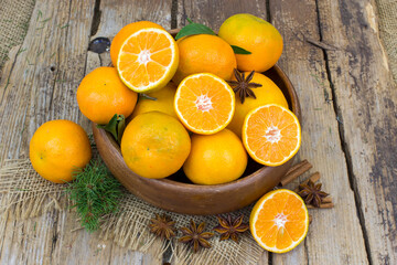 Obraz na płótnie Canvas fresh tangerines in a bowl on wooden background
