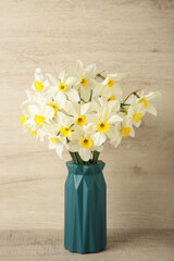 Spring easter background with daffodils bouquet in vase on light background