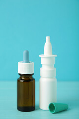 Bottles of nasal drops on blue background. Vertical photo