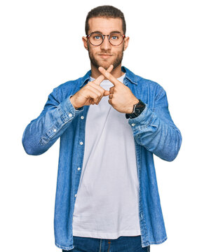 Young caucasian man wearing casual clothes rejection expression crossing fingers doing negative sign