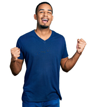 Young african american man wearing casual t shirt celebrating surprised and amazed for success with arms raised and open eyes. winner concept.