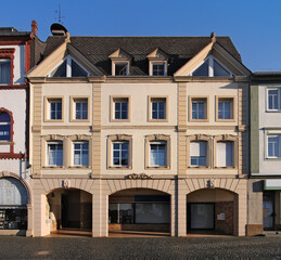 Fototapeta na wymiar Historical facade of a neo-baroque apartment house with shop arcade in the old town of Kirchberg, Rheinland-Pfalz region in Germany