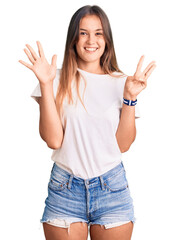 Beautiful caucasian woman wearing casual white tshirt showing and pointing up with fingers number eight while smiling confident and happy.