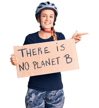 Beautiful caucasian woman holding there is no planet b banner smiling happy pointing with hand and finger to the side