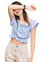 Young beautiful caucasian girl wearing casual clothes covering eyes with arm smiling cheerful and funny. blind concept.