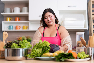 Obraz na płótnie Canvas Happy Asia plus size woman prepare cooking vegetables salad in kitchen at home 