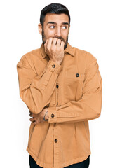 Young hispanic man wearing casual clothes looking stressed and nervous with hands on mouth biting nails. anxiety problem.